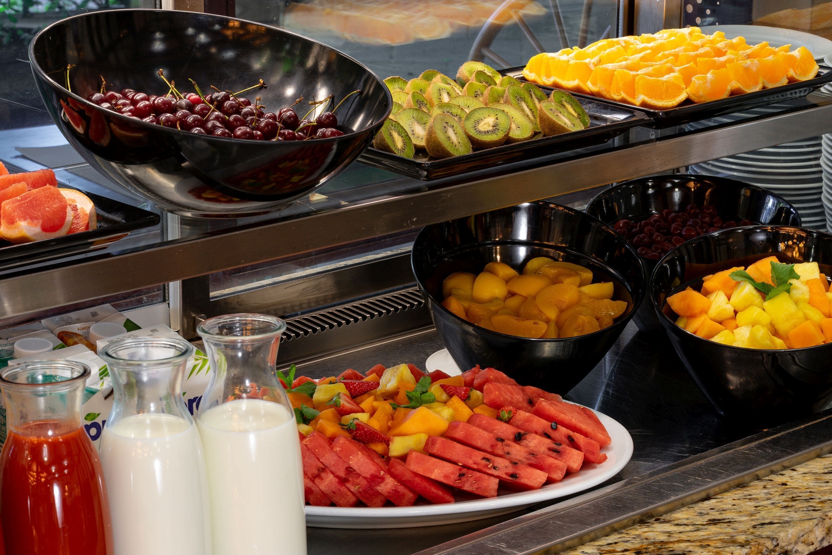 A buffet with various fruits and beverages.