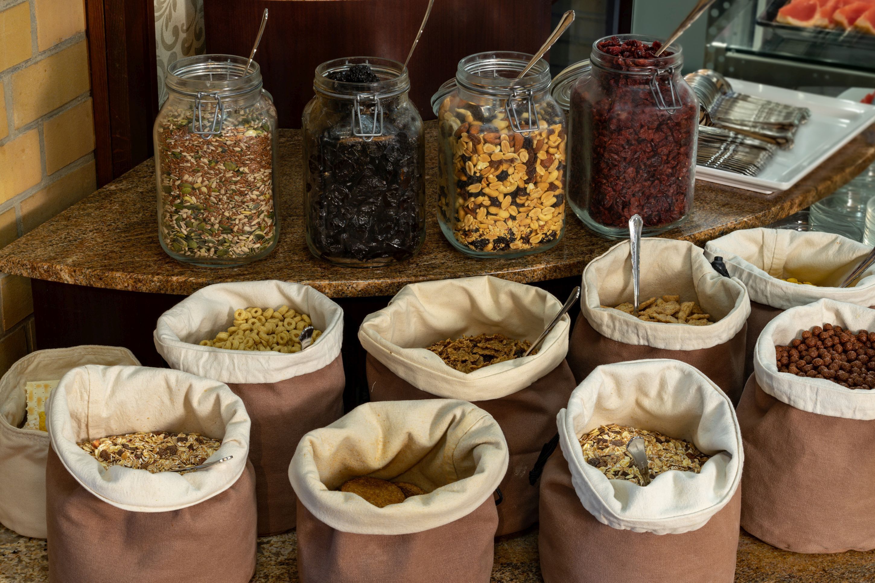Un bufé con diversos alimentos en frascos y bolsas.