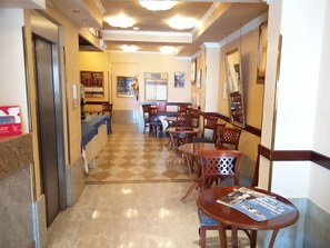 Um saguão de hotel com balcão de recepção, área de estar e balcão de check-out.