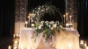 A table set with white flowers and candles, surrounded by draped curtains and patterned wallpaper. - Holiday Inn Newcastle Jesmond by IHG (Newcastle-upon-Tyne)