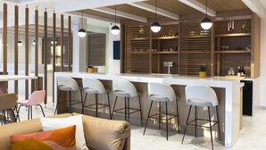 Une cuisine moderne dotée d’un îlot central, de tabourets de bar et de luminaires suspendus.
