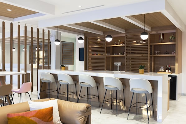 Une cuisine moderne dotée d’un îlot central, de tabourets de bar et de luminaires suspendus.