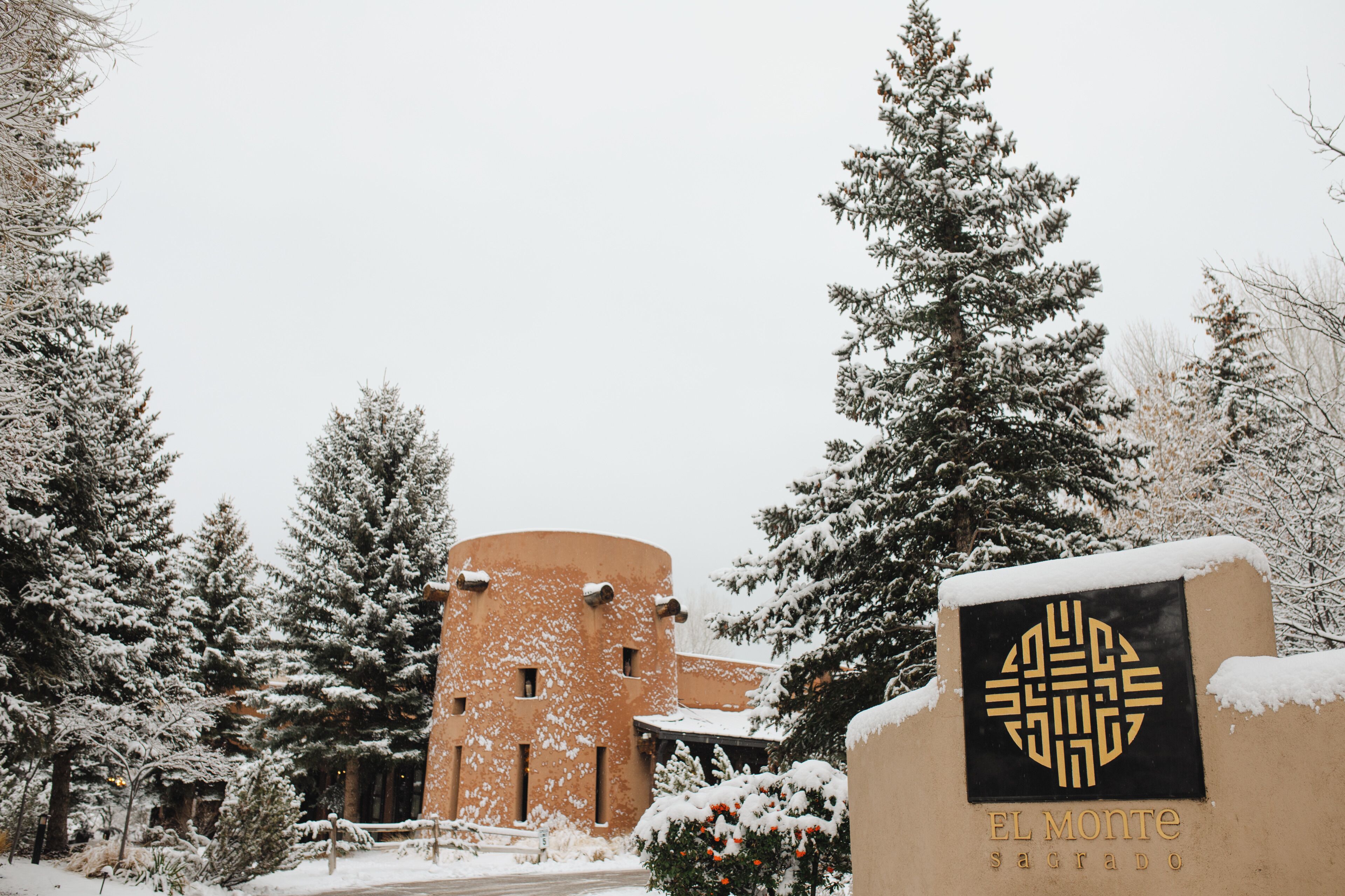 Un edificio cubierto de nieve con una torre circular y un letrero que dice 'EL MONTE Sagrado'.