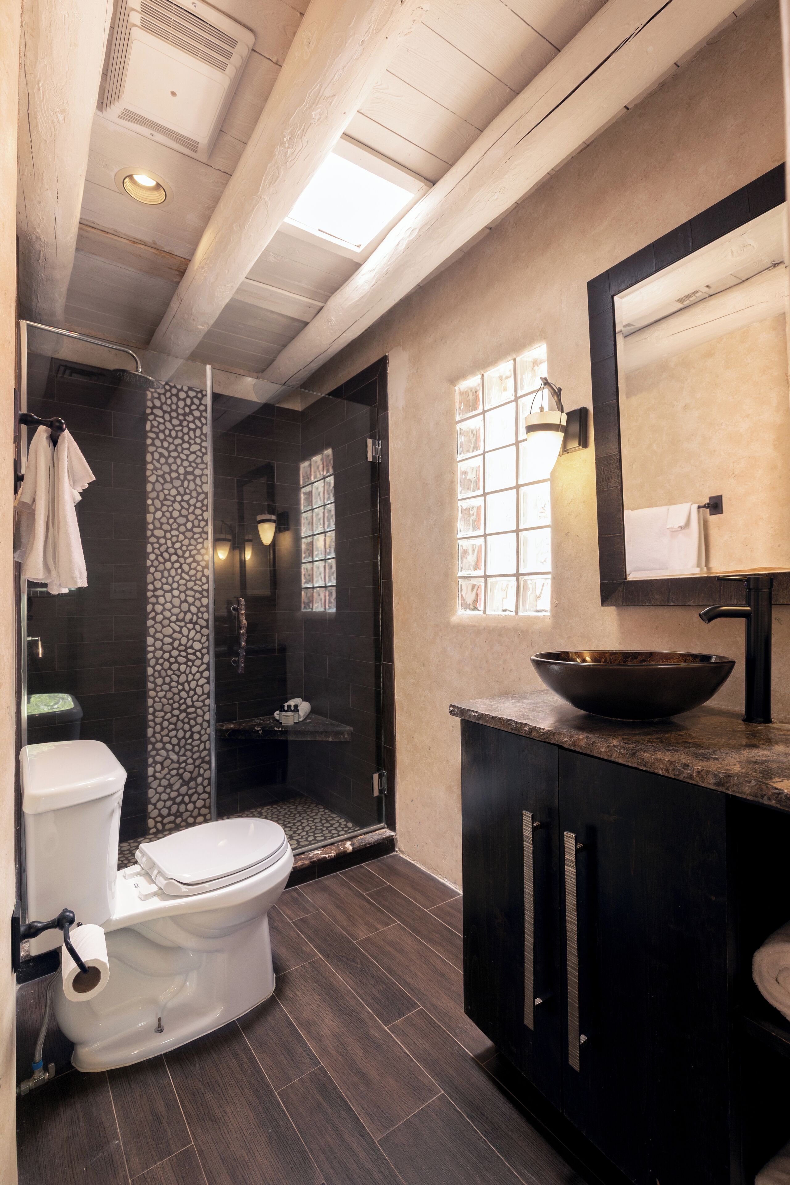 Un baño moderno con inodoro, lavabo y ducha.