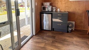 A compact kitchen with a microwave, toaster, and small refrigerator. - Parklands Motorlodge (Turangi)