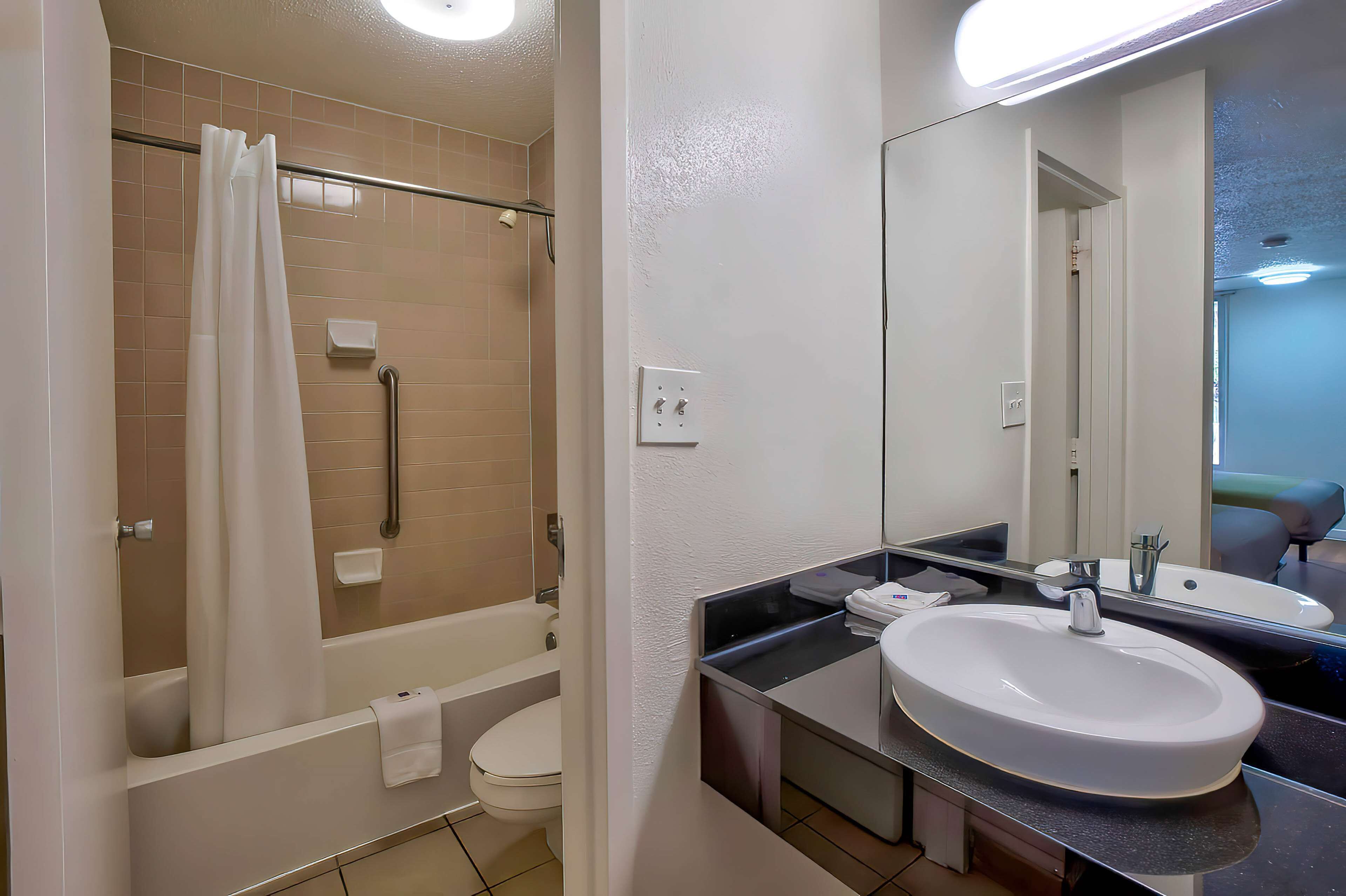 A modern bathroom with a bathtub, toilet, and sink.
