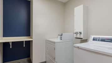 A laundry room with a washing machine, dryer, and a cabinet.