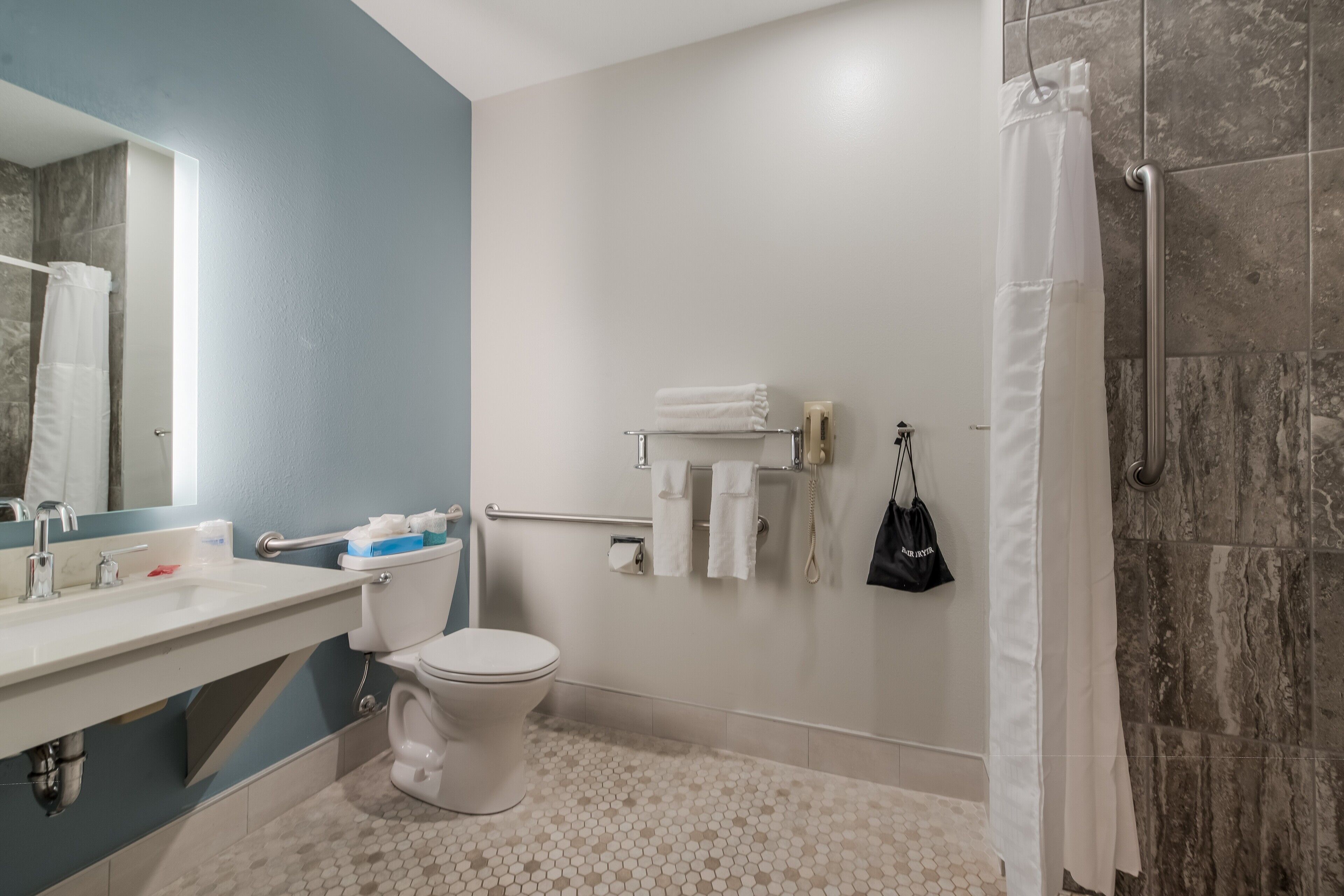 A bathroom with a toilet, sink, and shower.
