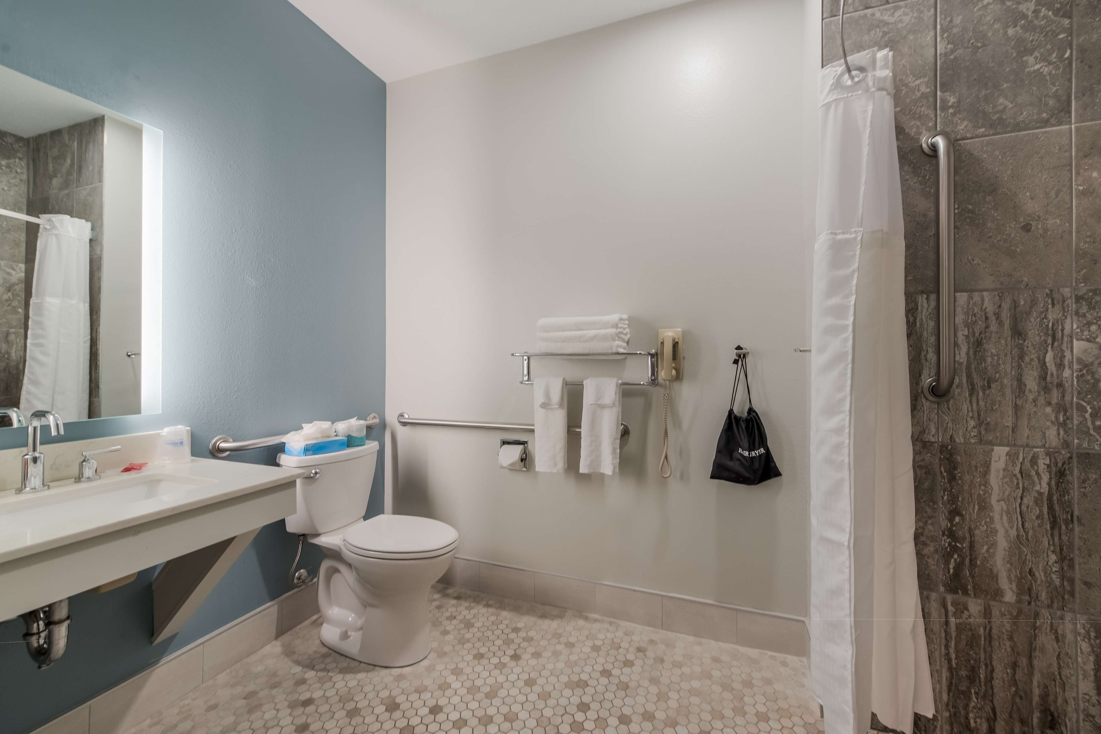 A modern bathroom with a toilet, sink, and shower area.