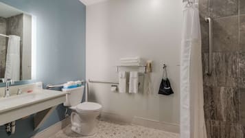 A modern bathroom with a toilet, sink, and shower area.