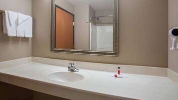 A bathroom with a white sink, a mirror, and a towel rack.