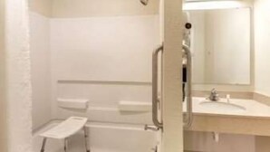 A bathroom with a shower, a toilet, and a sink.