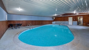 An indoor swimming pool with a tiled floor, wooden walls, and a metal ceiling. - Travelodge by Wyndham Livingston Yellowstone (Livingston)