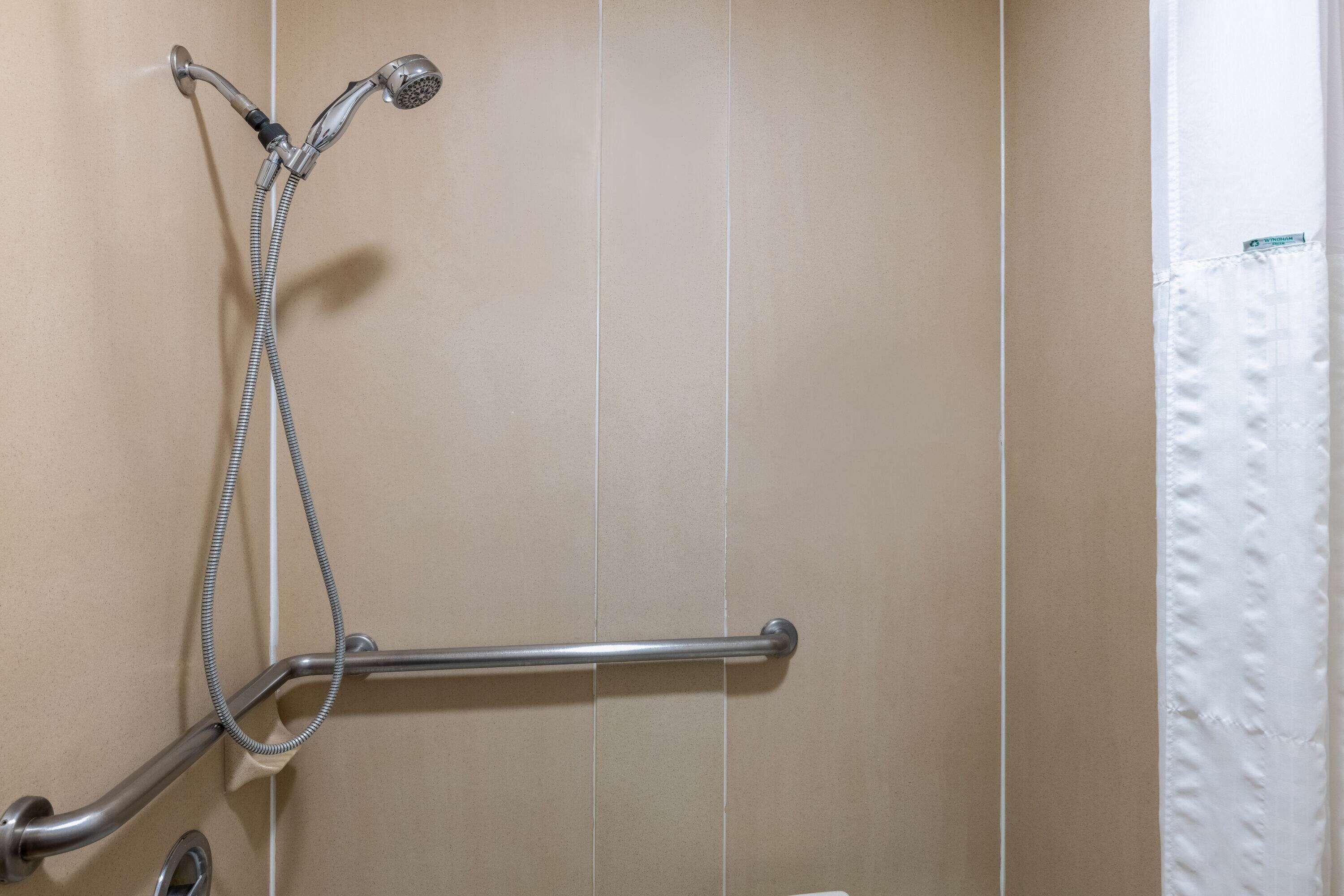 Une salle de bain équipée d’une douche, d’une barre d’appui et d’un porte-serviettes.