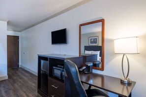 Escritorio, cortinas blackout y tabla de planchar con plancha