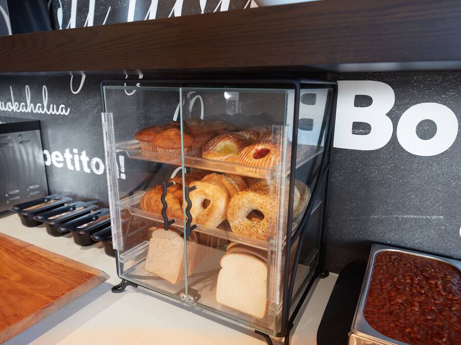 A bakery display with various baked goods and bread.