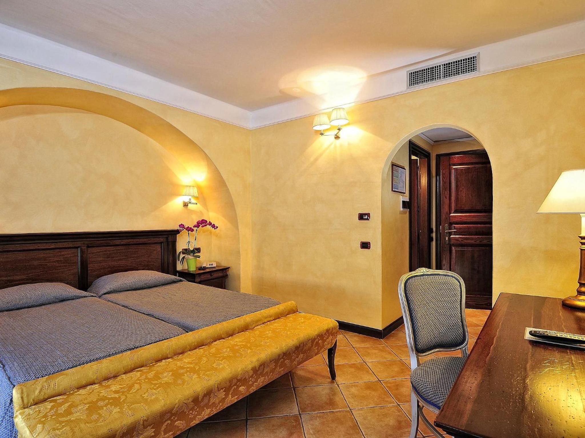 Een hotelkamer met een bed, een stoel, een bureau en een deur.