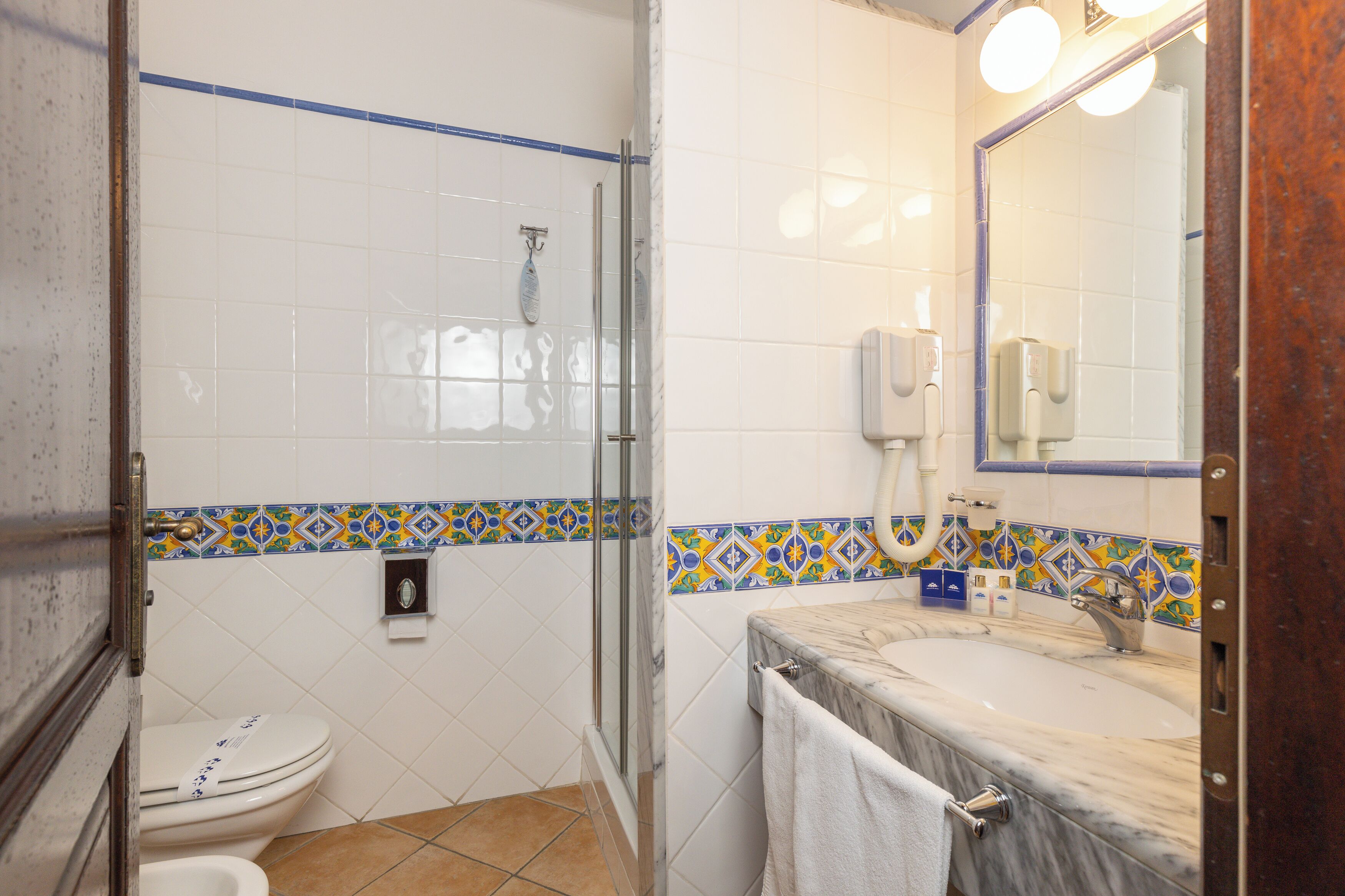A bathroom with a toilet, shower, and sink.