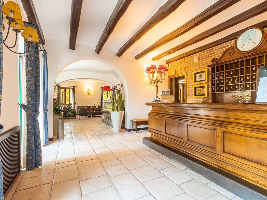 A reception area with a wooden counter, a clock, and a reception desk.