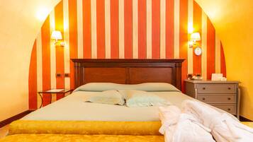 A hotel room with a large bed, two bedside lamps, a nightstand, and a wooden headboard.