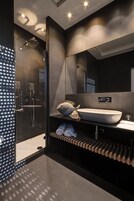 Un bagno moderno con doccia vetrata, lavandino capiente e porta asciugamani.