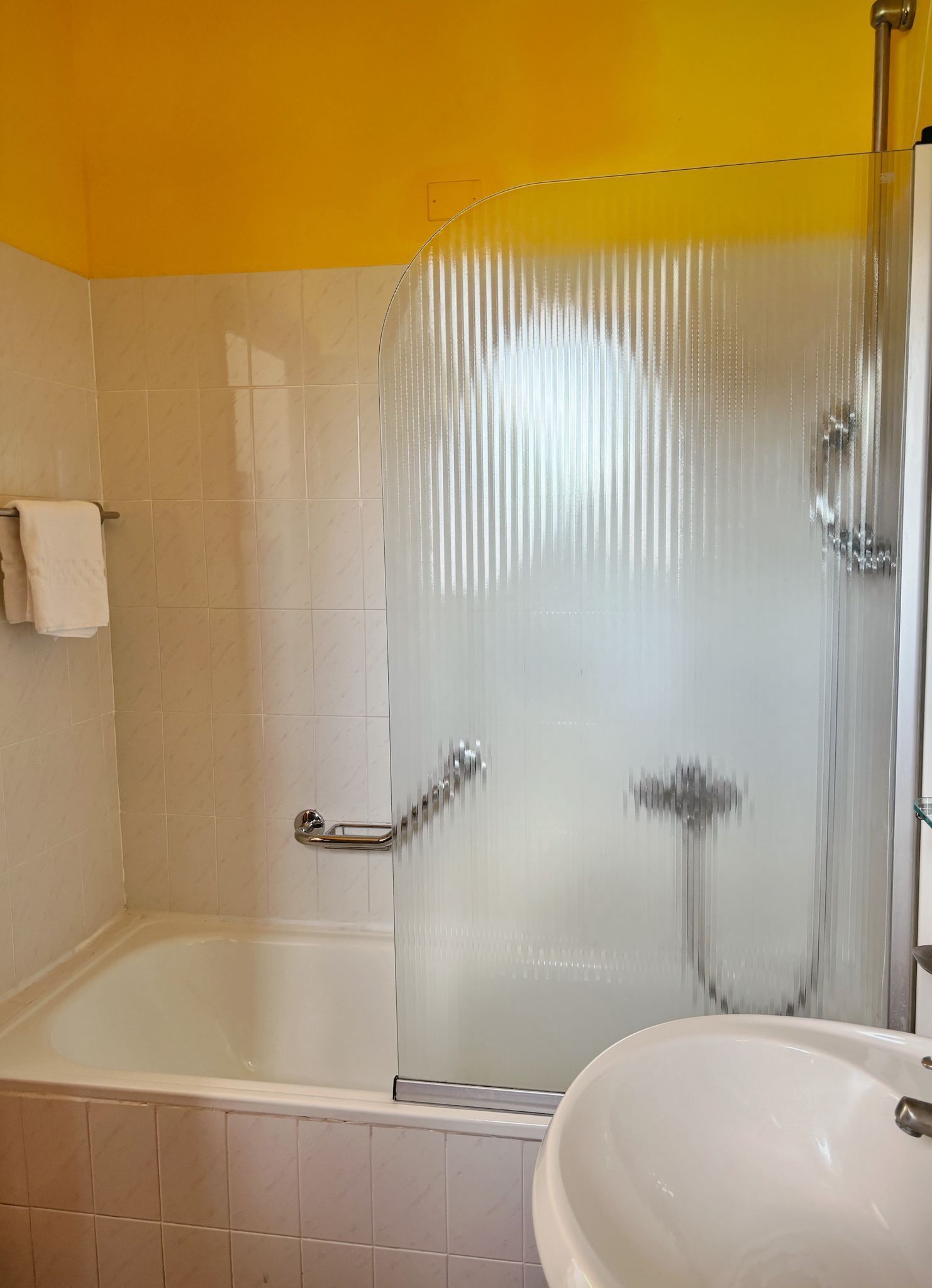 Un baño con bañera, cabina de ducha de vidrio y lavamanos.