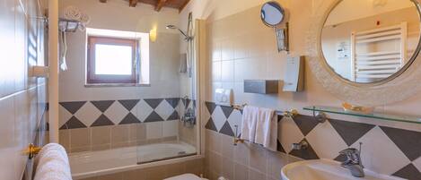 A bathroom with a bathtub, two sinks, a toilet, and a shower.