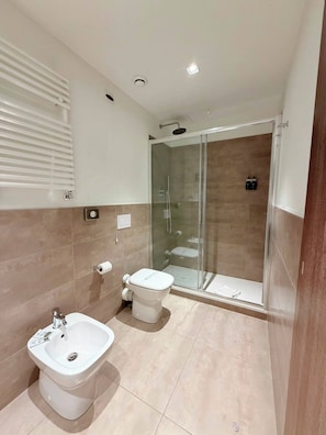 A modern bathroom with a glass-enclosed shower, a bidet, and a sink. - Best Quality Hotel Politecnico (Turin)
