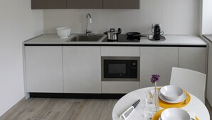 Eine moderne Küche mit Mikrowelle, Spüle und Kaffeemaschine.