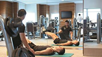 A gym with exercise equipment and a large mirror.