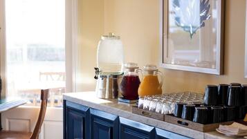 A kitchen with a blue cabinet, a coffee maker, and a fruit pitcher.