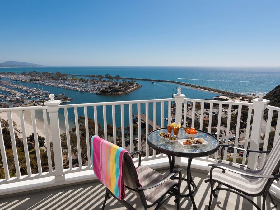 A balcony with a view of a marina and the ocean.