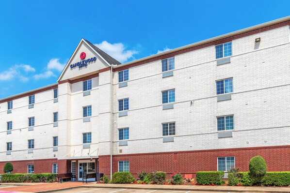 A multi-story hotel with a prominent red-brick facade and a white exterior. - Candlewood Suites Tyler by IHG (Tyler)