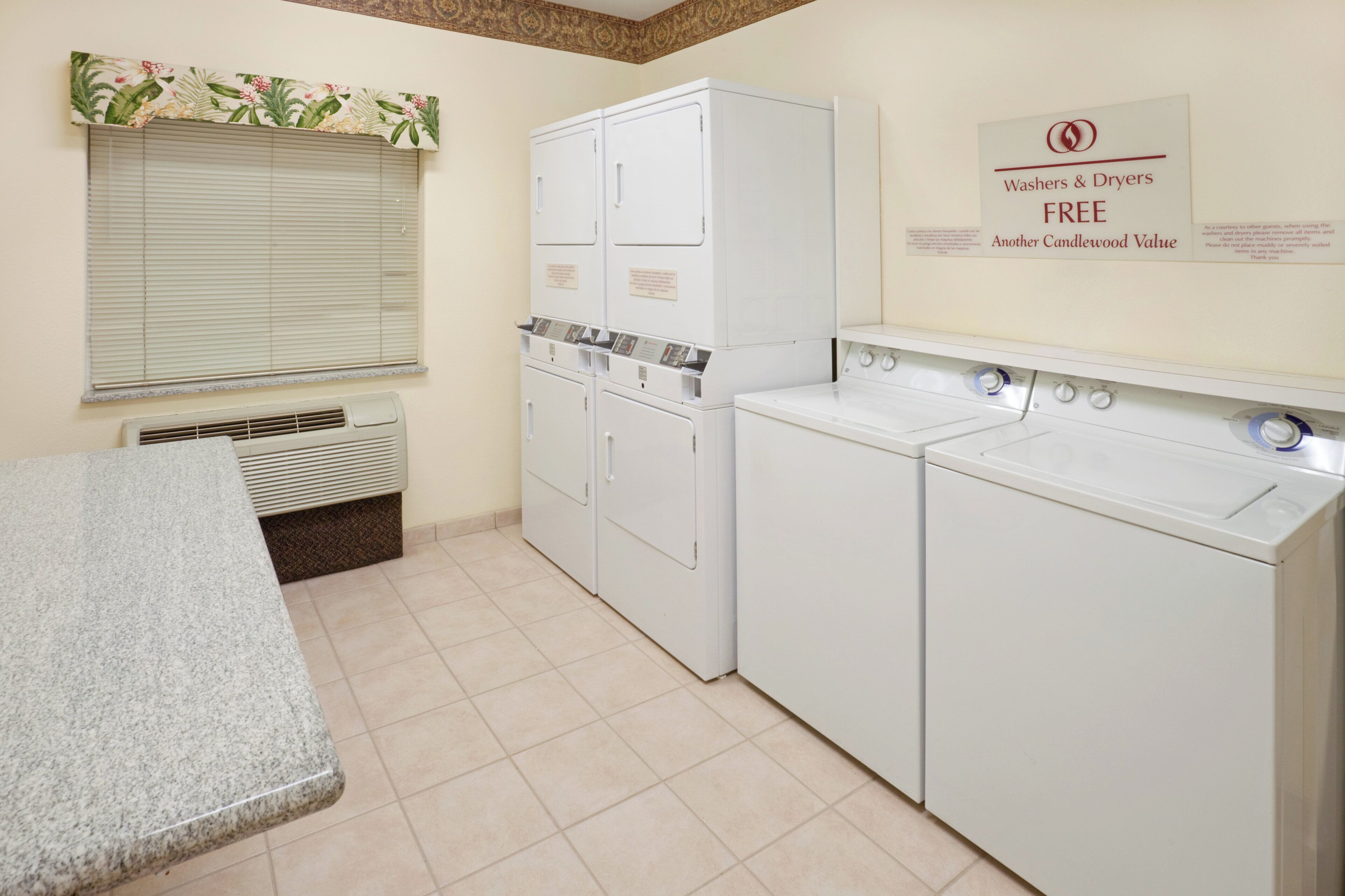 A laundry room with a washing machine, dryer, and a sign indicating free washers and dryers.