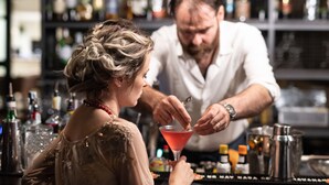 Un bar con un cantinero preparando una bebida.