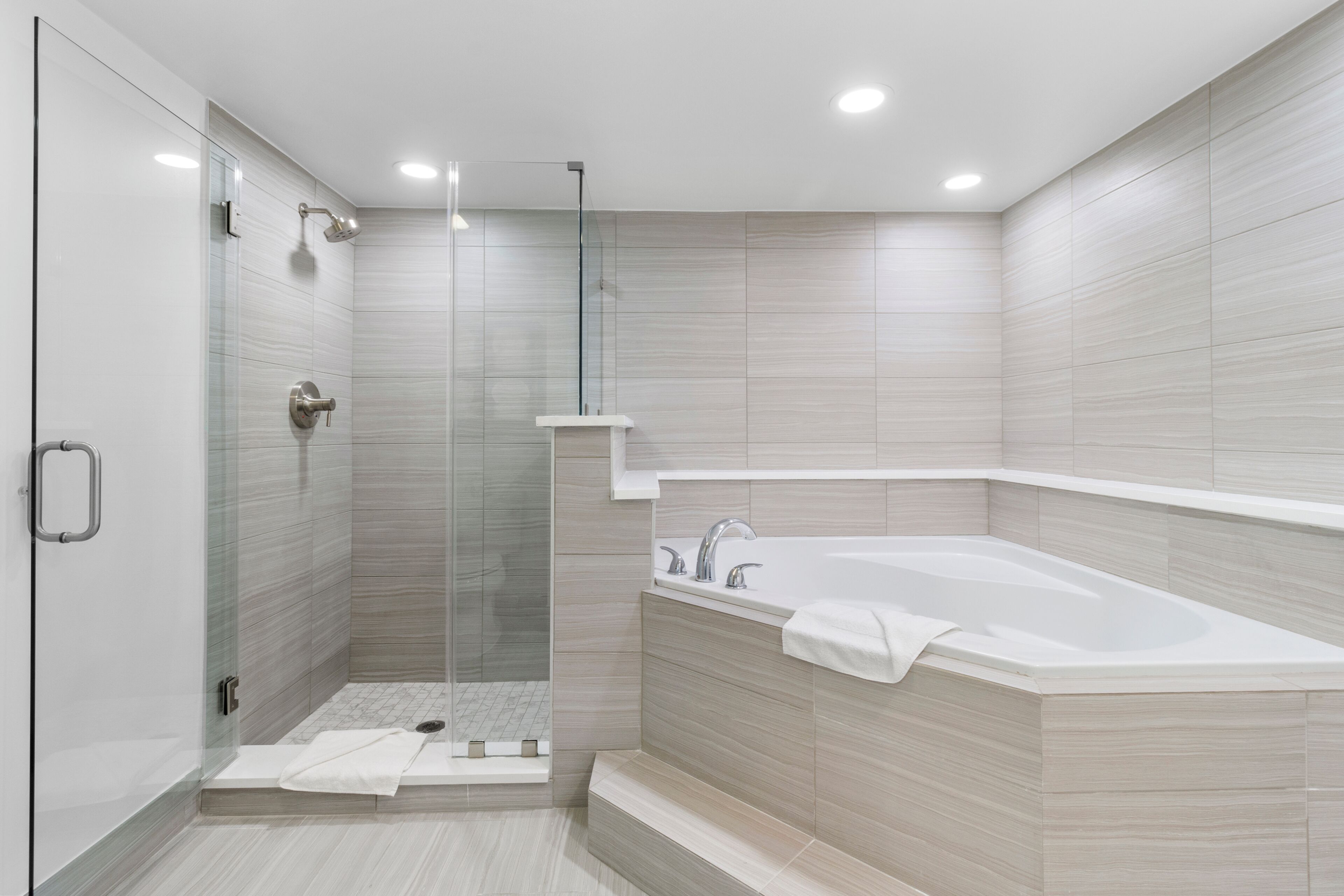 A modern bathroom with a glass-enclosed shower, a freestanding bathtub, and a walk-in shower area.