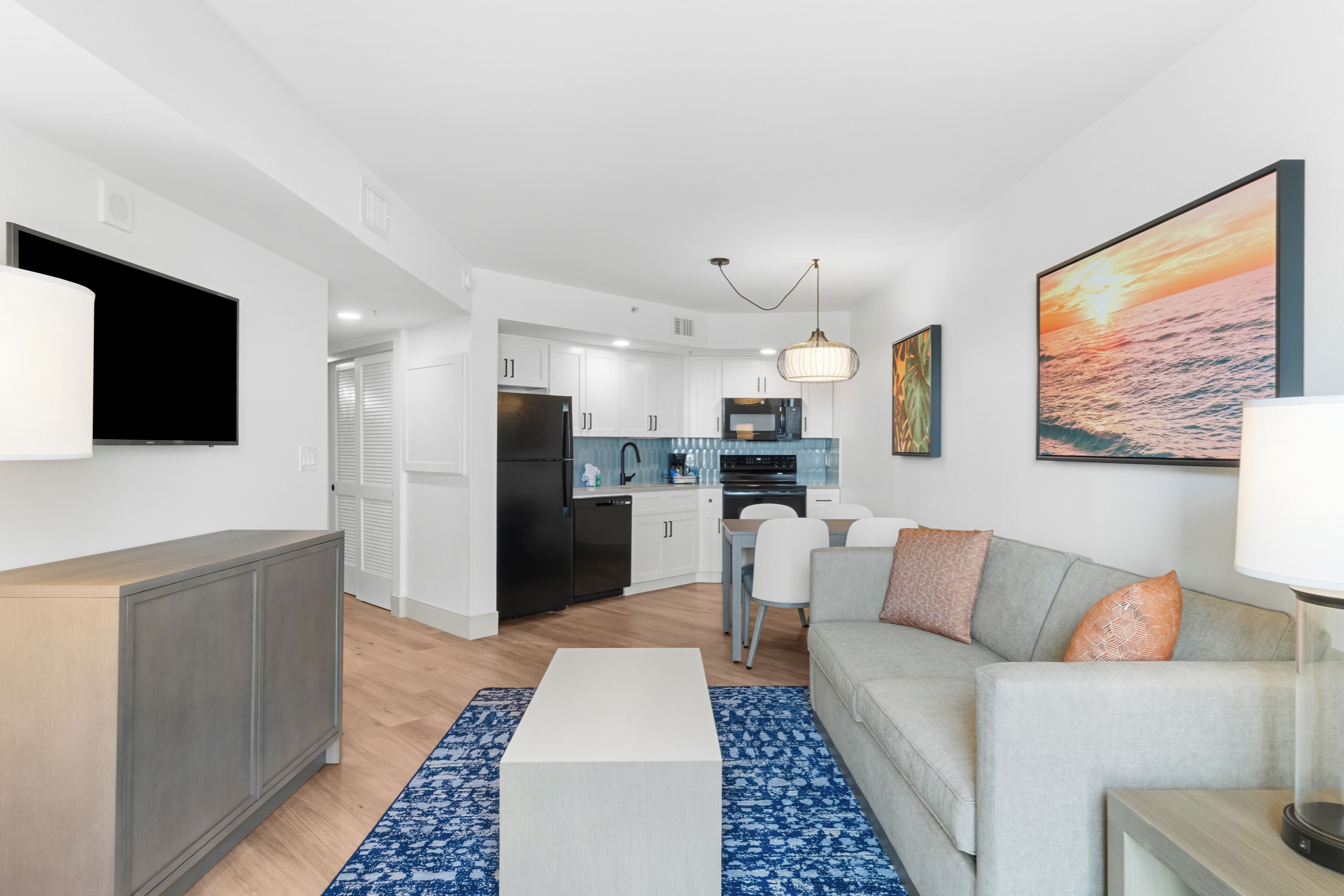 A modern apartment with a living room, kitchen, and dining area.