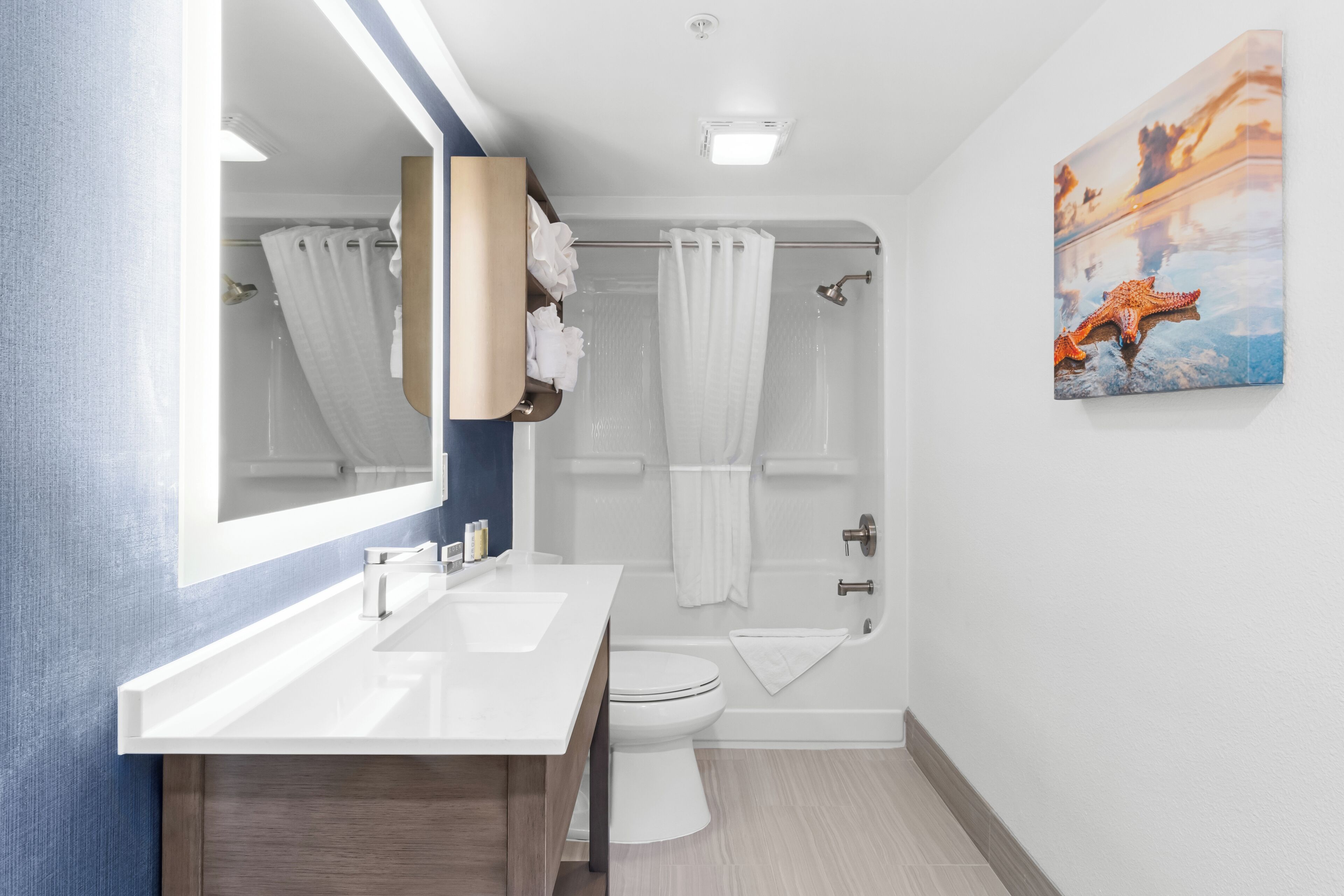 A modern bathroom with two sinks, a toilet, and a shower.
