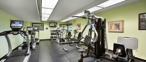 Ein Fitnessstudio mit Laufbändern, Kraftgeräten und Trainingsausrüstung.