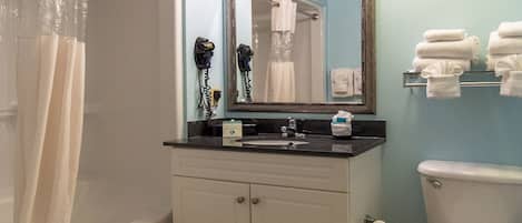 A bathroom with a bathtub, a sink with a mirror above it, and a toilet.