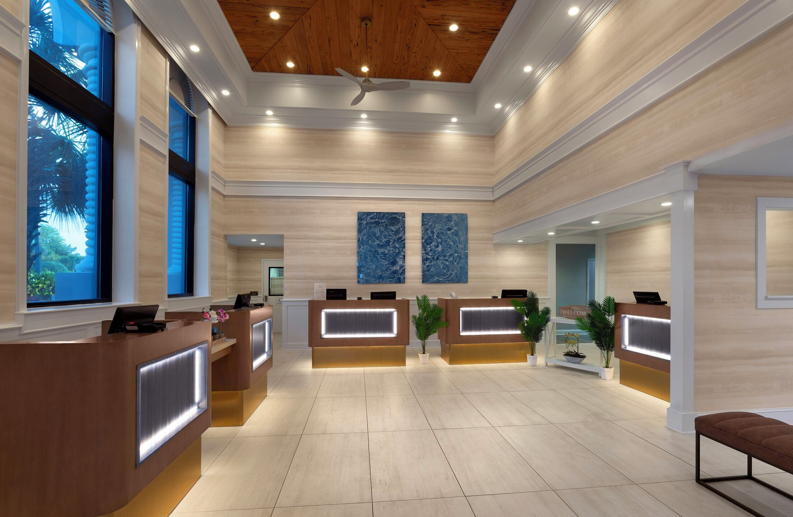A reception area with multiple counters, a wooden ceiling, and large windows.