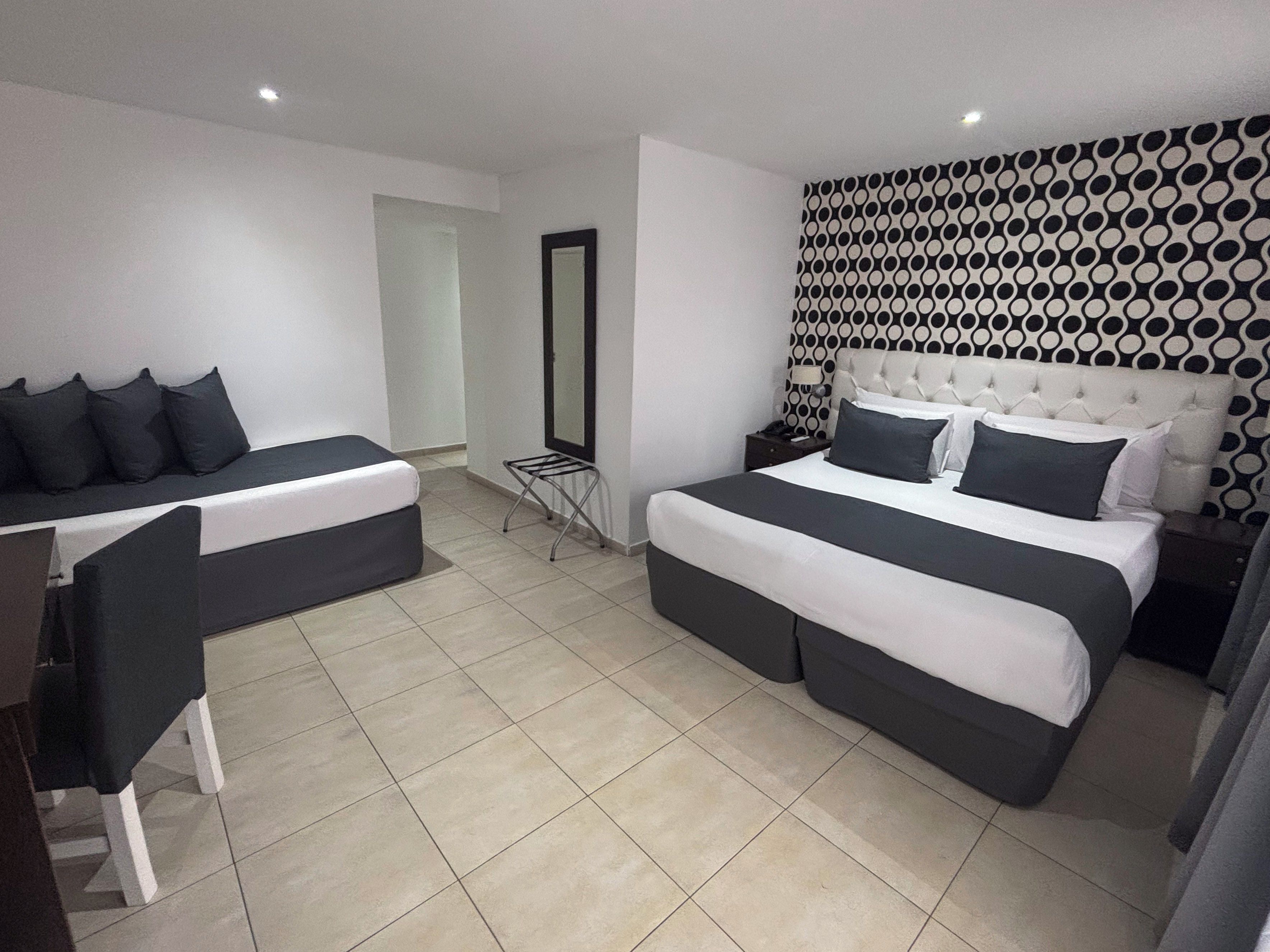 A hotel room with a bed, a desk, and a chair.