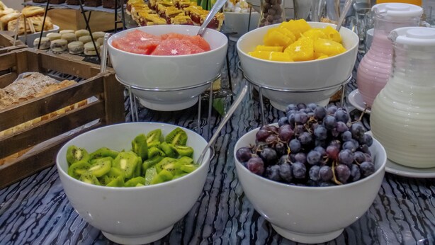 A buffet with various fruits, vegetables, and desserts.