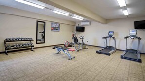 A gym with treadmills, a bench press, dumbbells, and a stationary bike. - North Platte Inn & Suites (North Platte)