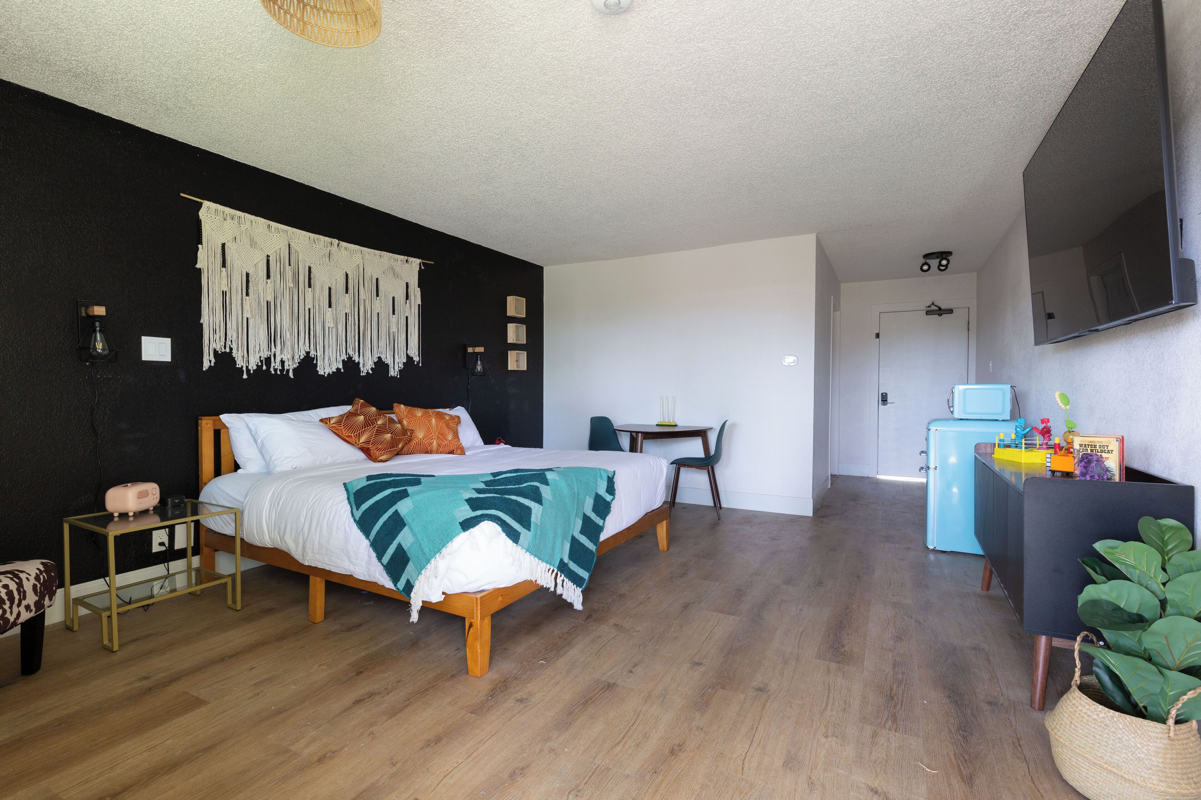 A bedroom with a bed, bedside table, and a small desk with a chair.