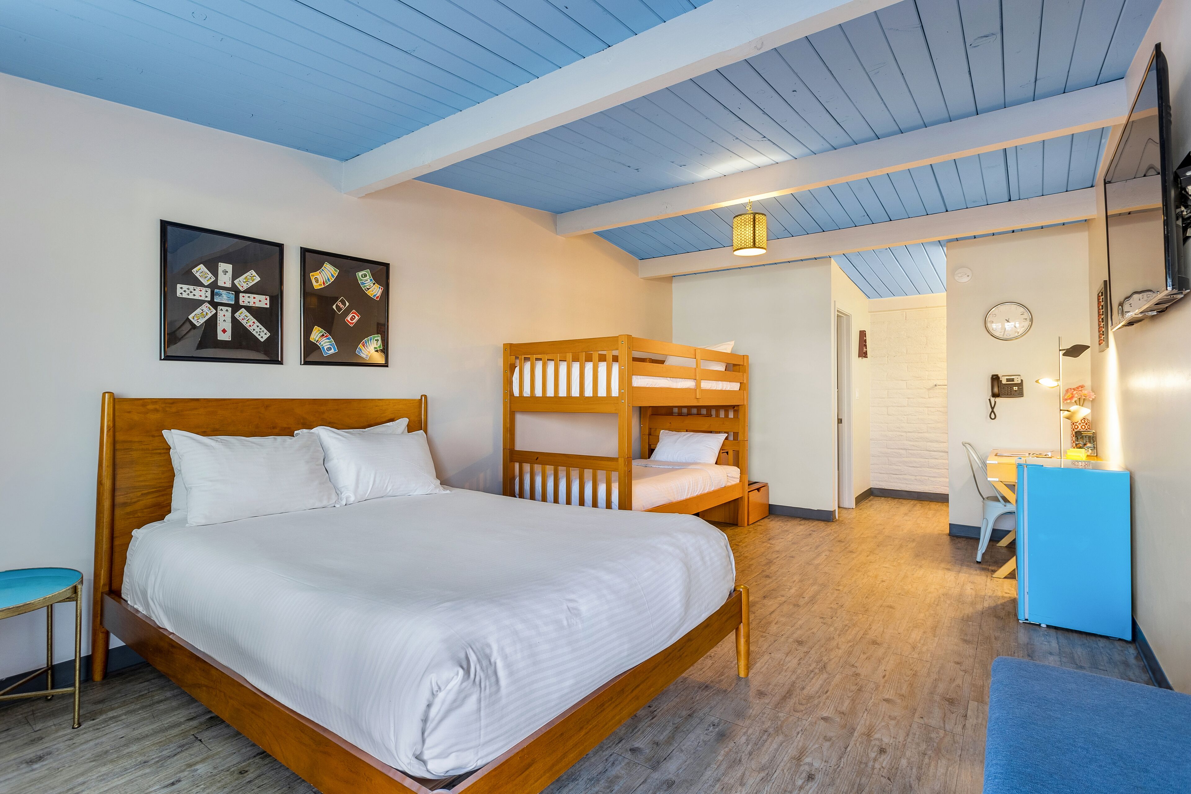 Een slaapkamer met een groot bed, een stapelbed, een bureau en een stoel.