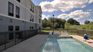 A swimming pool with a view of a building and trees in the background.