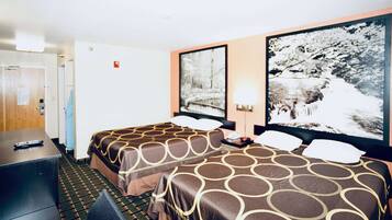 Habitación de hotel con dos camas, un escritorio, una silla, una lámpara y un cuadro en la pared.