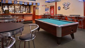 A bar area with a pool table, stools, and a bar counter with various beer brands displayed. - Castle Inn & Suites Anadarko (Anadarko)