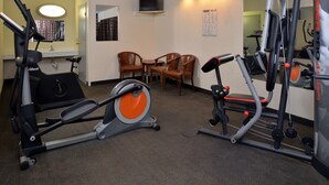 A gym with exercise equipment, chairs, and a mirror. - Castle Inn & Suites Anadarko (Anadarko)
